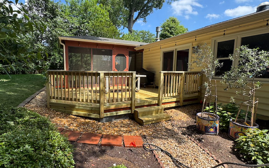 A house with a wooden deck and a screened in porch.