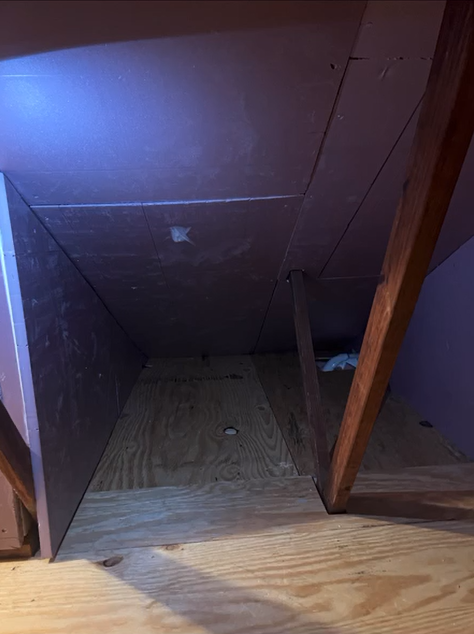 An attic with a wooden floor and a wooden ceiling.
