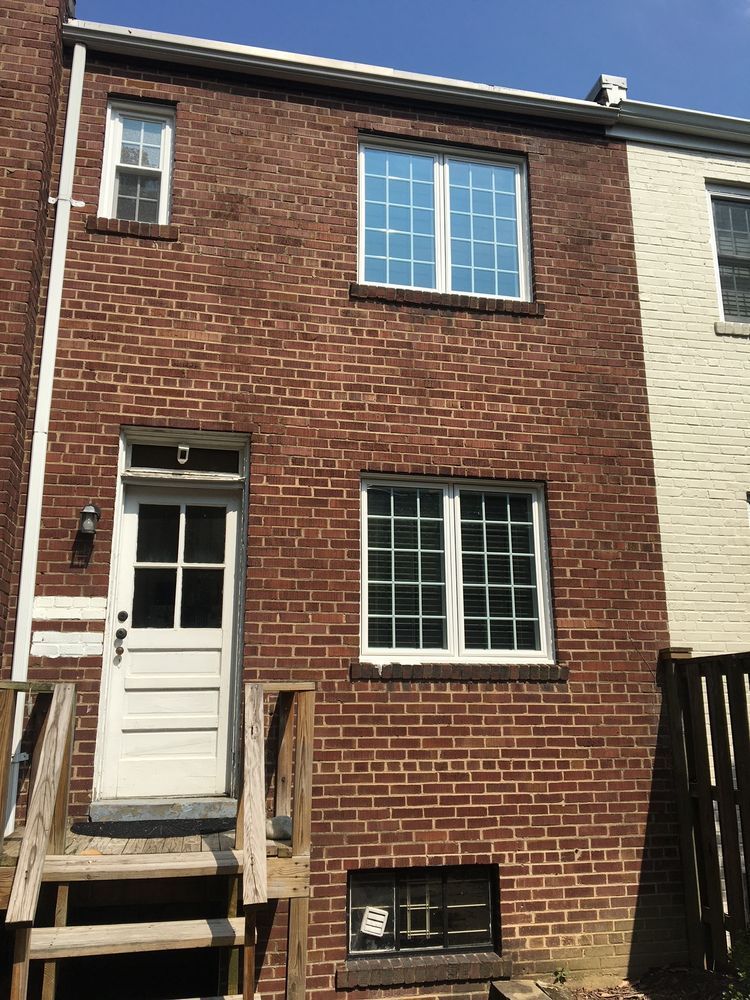A brick building with a white door and windows