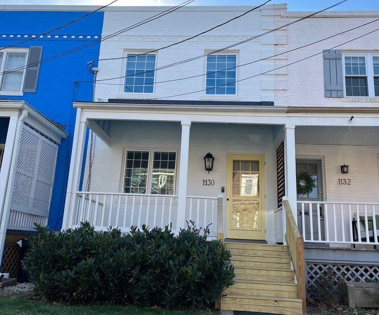 A blue and white house with a porch and stairs