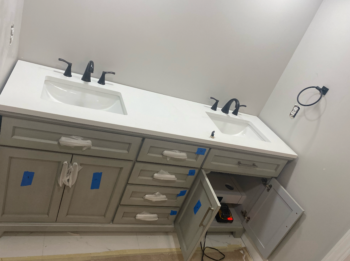 A bathroom vanity with two sinks and a toilet.