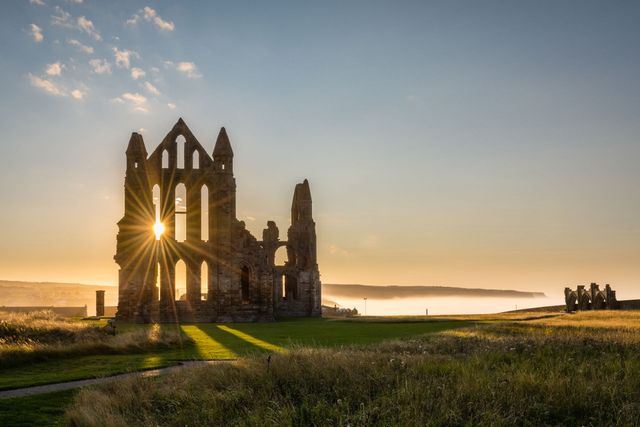 The sun is shining through the windows of a ruined building.