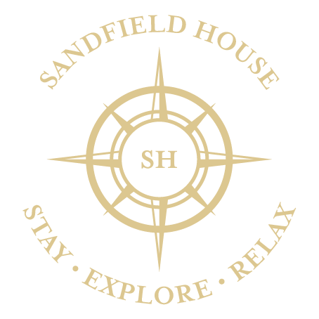 The logo for sandfield house says stay explore relax