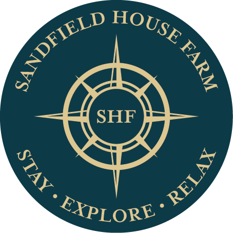 The logo for sandfield house farm says to stay explore and relax