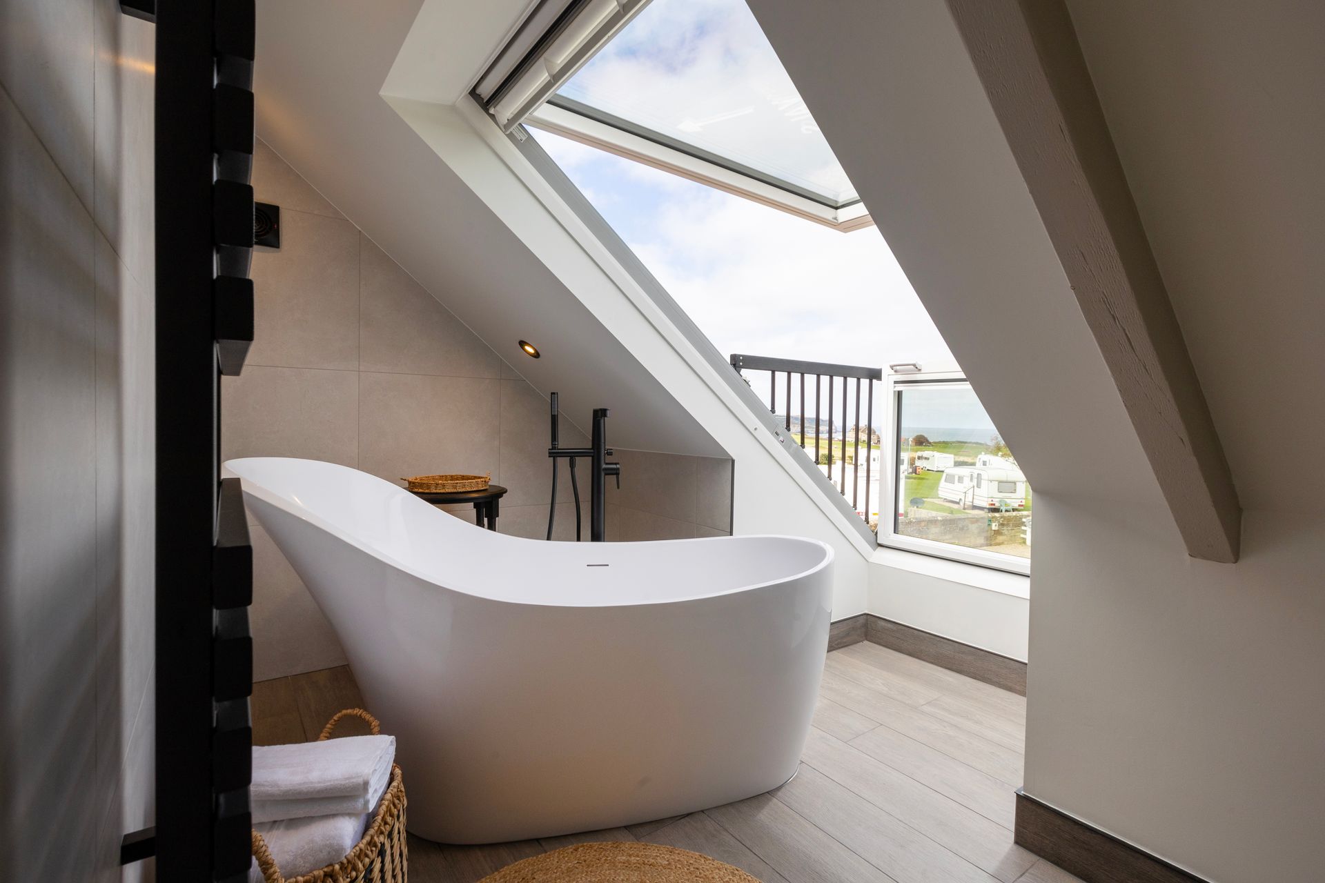 A bathroom with a bathtub and a skylight.