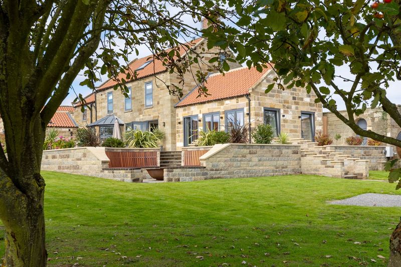 A large house with a large lawn in front of it.