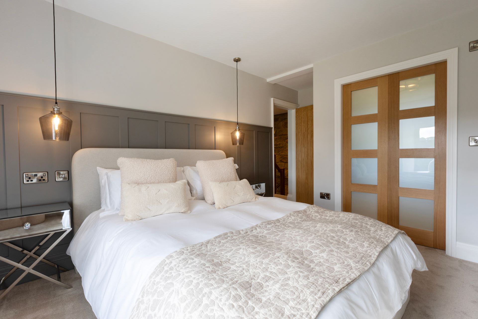 A bedroom with a large bed and sliding glass doors.