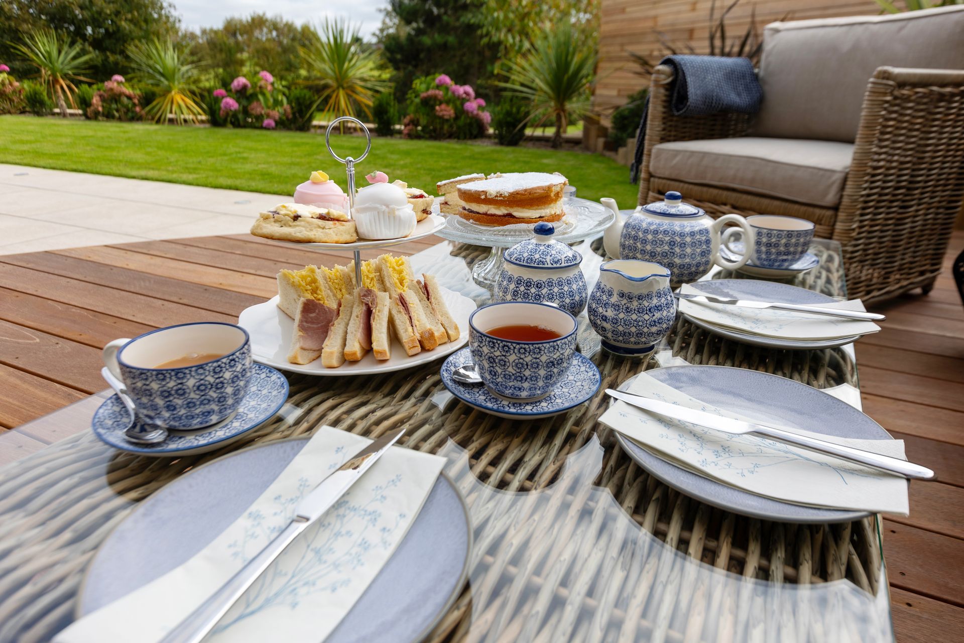A table topped with plates of food and cups of tea.