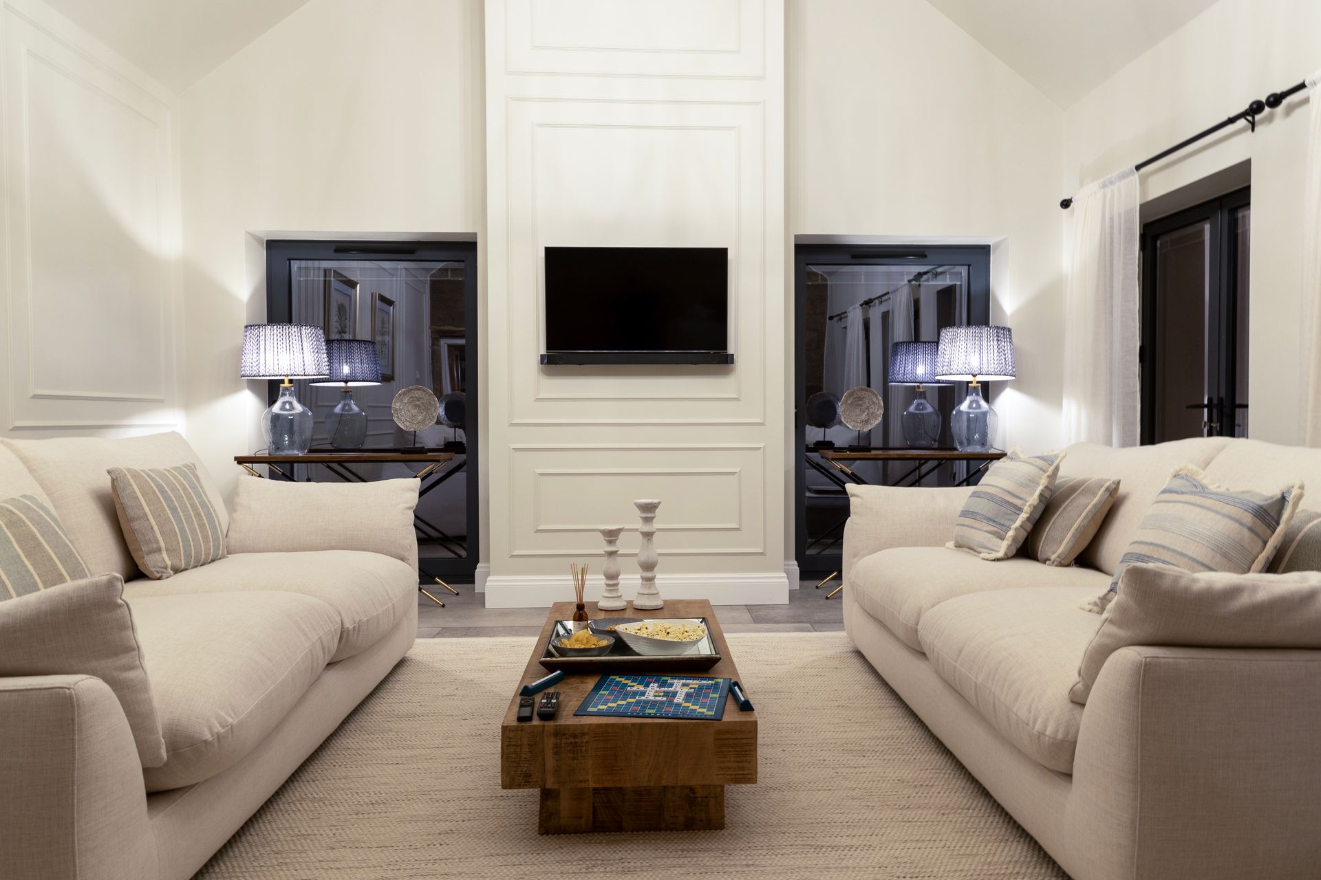 A living room with two couches , a coffee table , and a flat screen tv.
