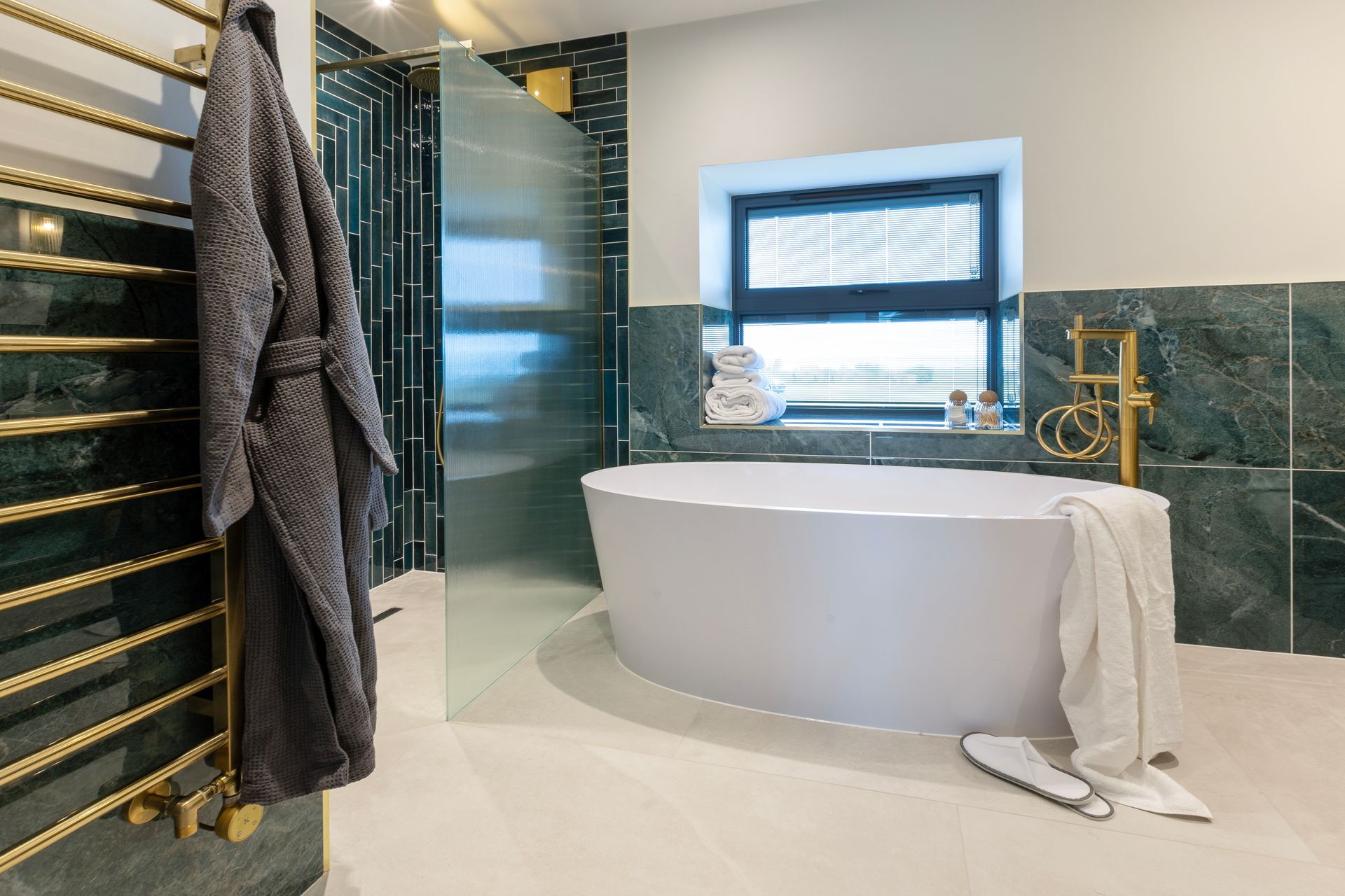 A bathroom with a bathtub , shower , and window.