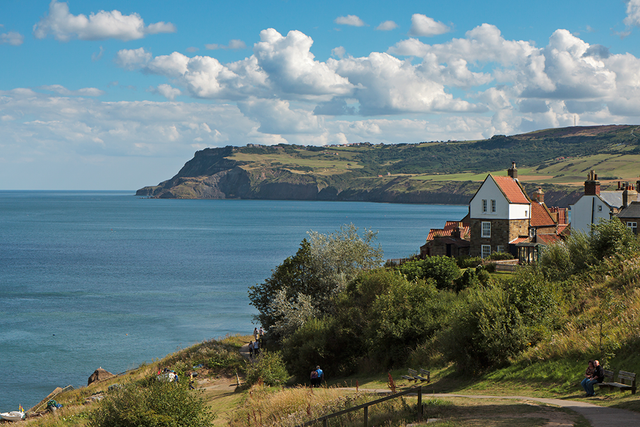 There is a house on the cliff overlooking the ocean.