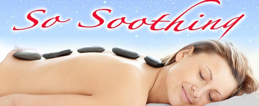 Woman receiving a mud body treatment at a spa; hands applying mud to her back; relaxed expression.