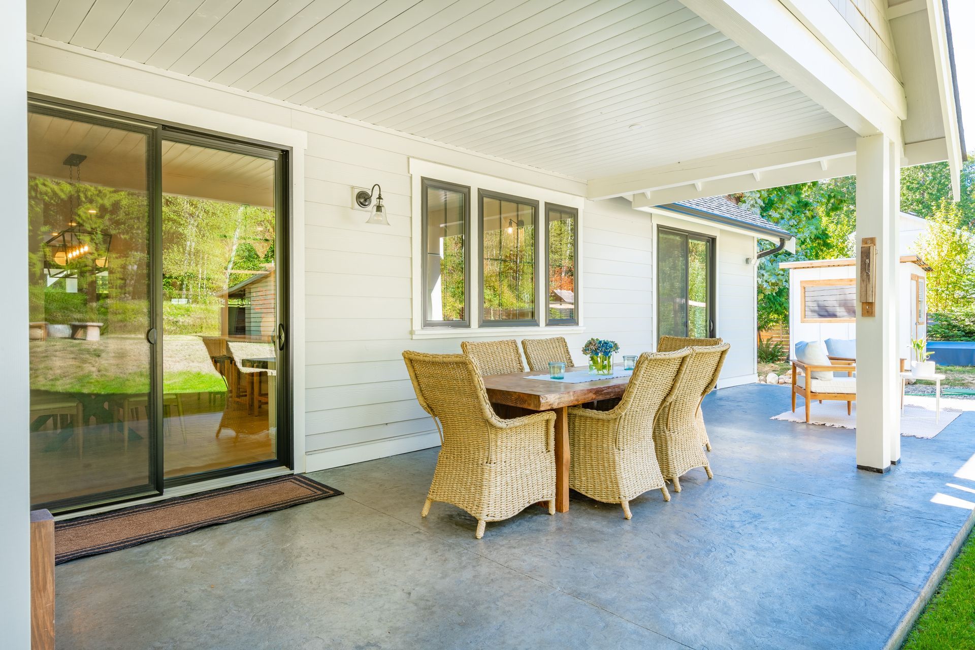 There is a table and chairs on the patio of a house.