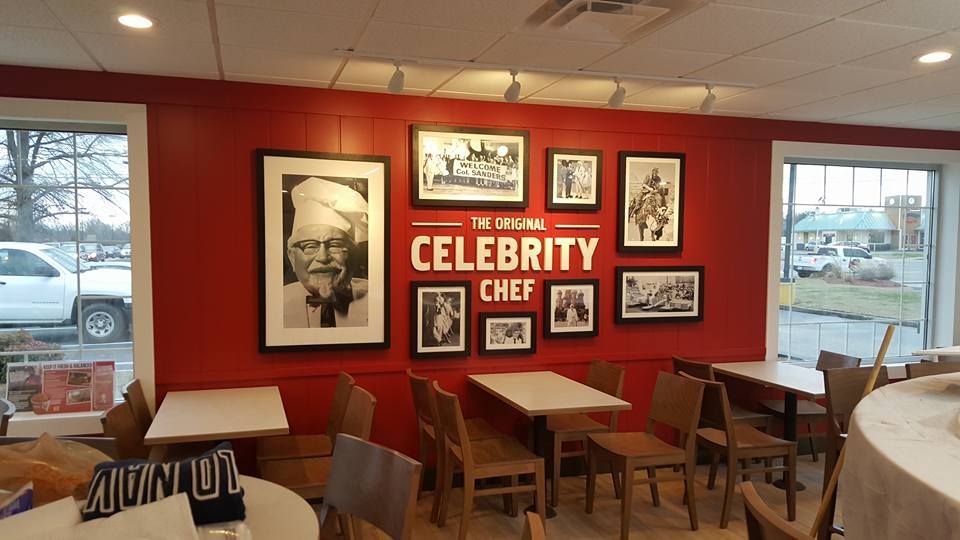 KFC restaurant interior with red wall, photos of Colonel Sanders, 