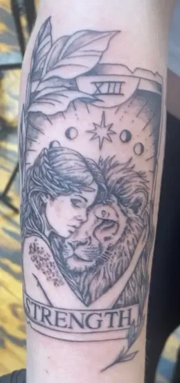 Tattoo of a woman embracing a lion.