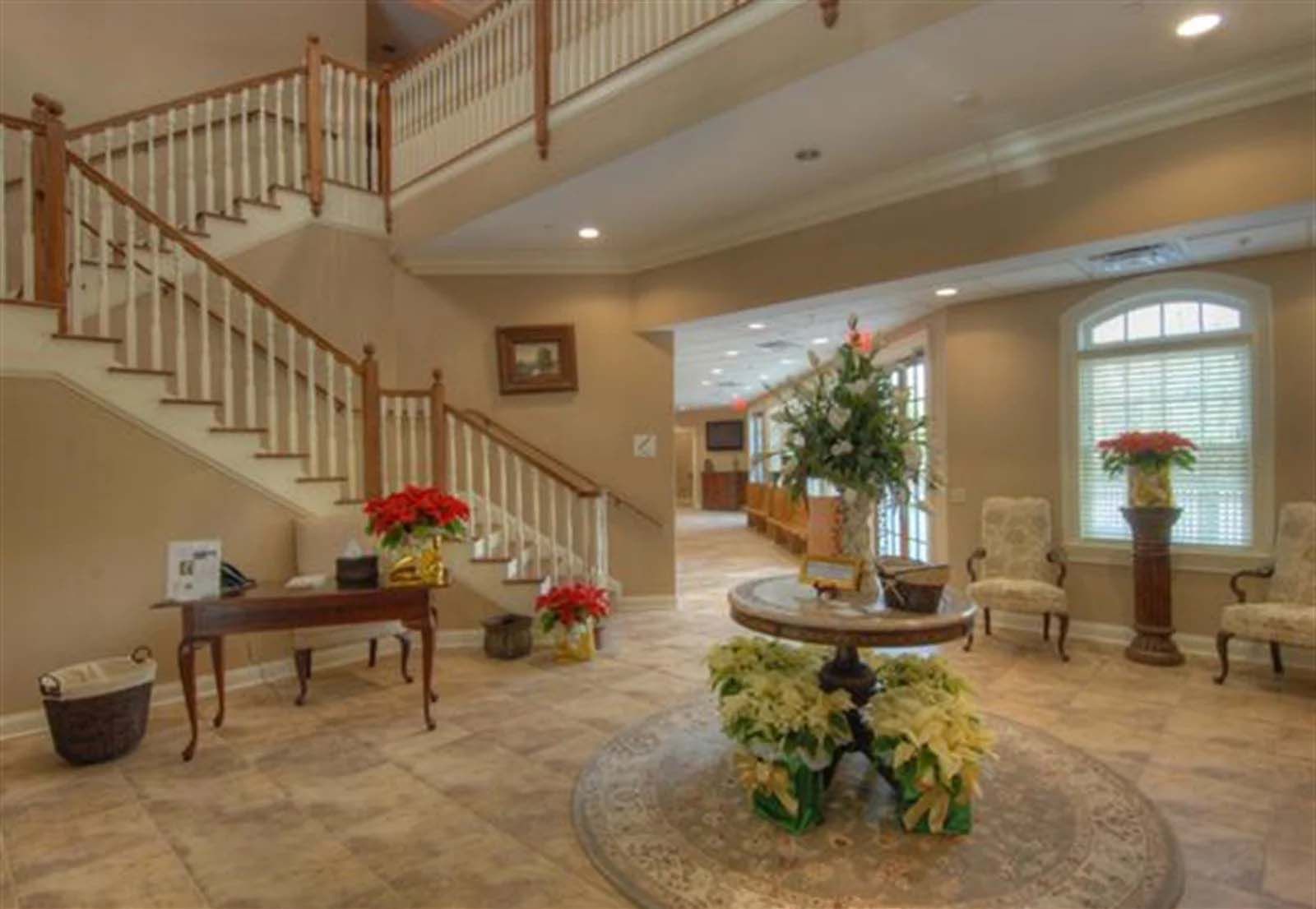 There is a table with flowers on it in the middle of the room.