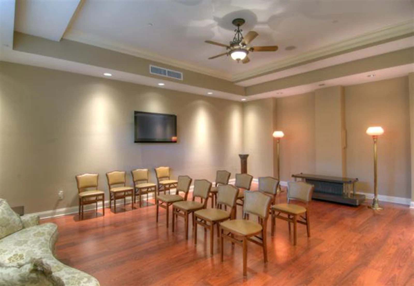 A room with a lot of chairs and a ceiling fan