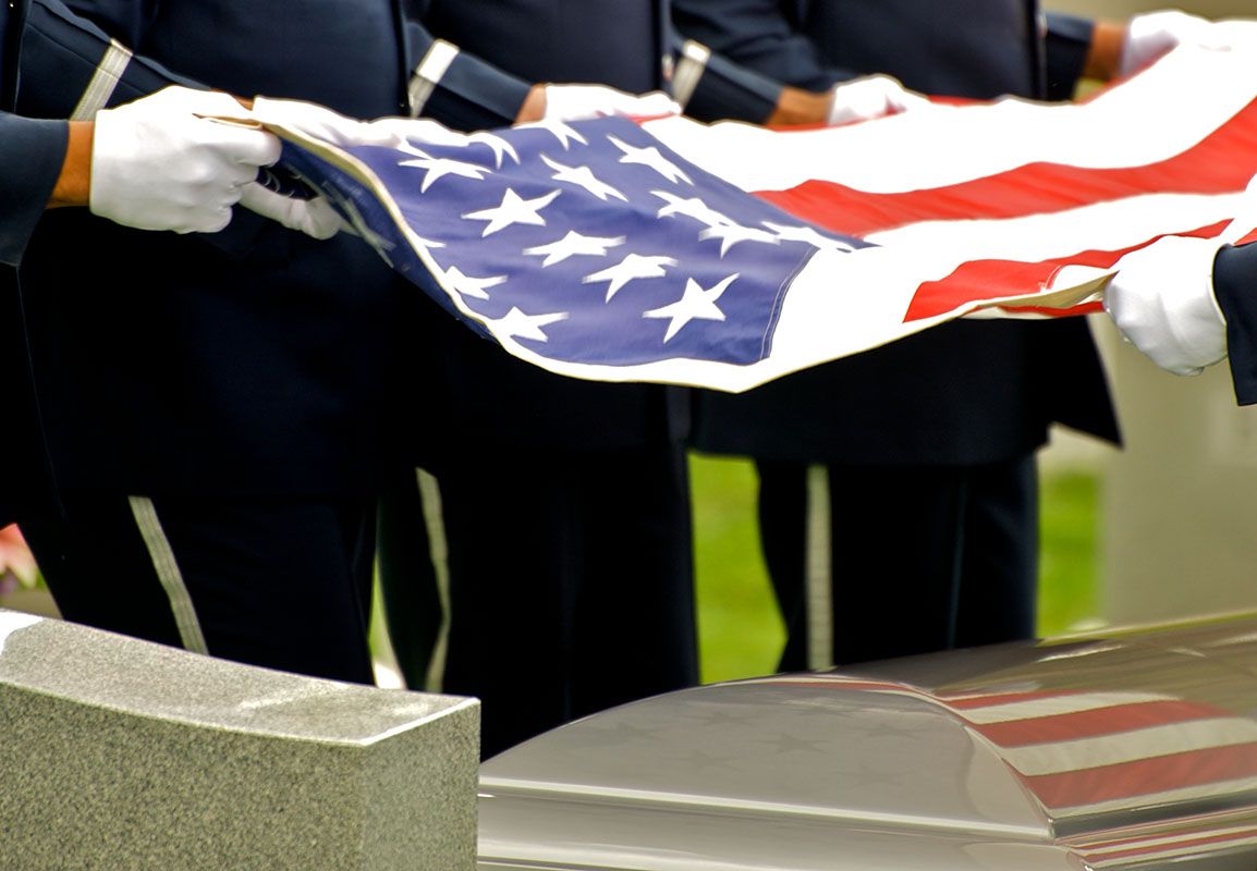 A group of people holding an american flag over a coffin