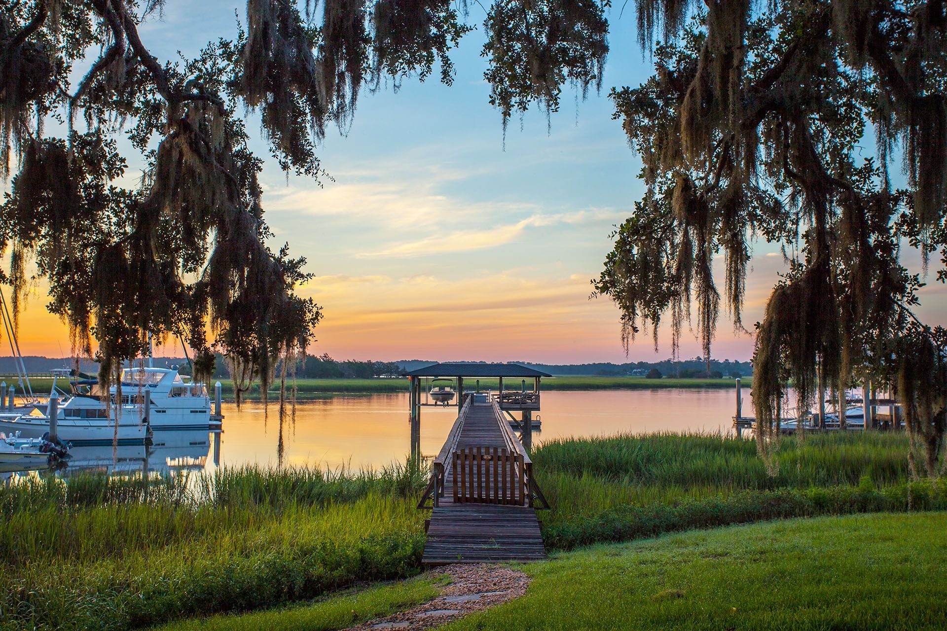 A sunset over a body of water with a dock in the foreground