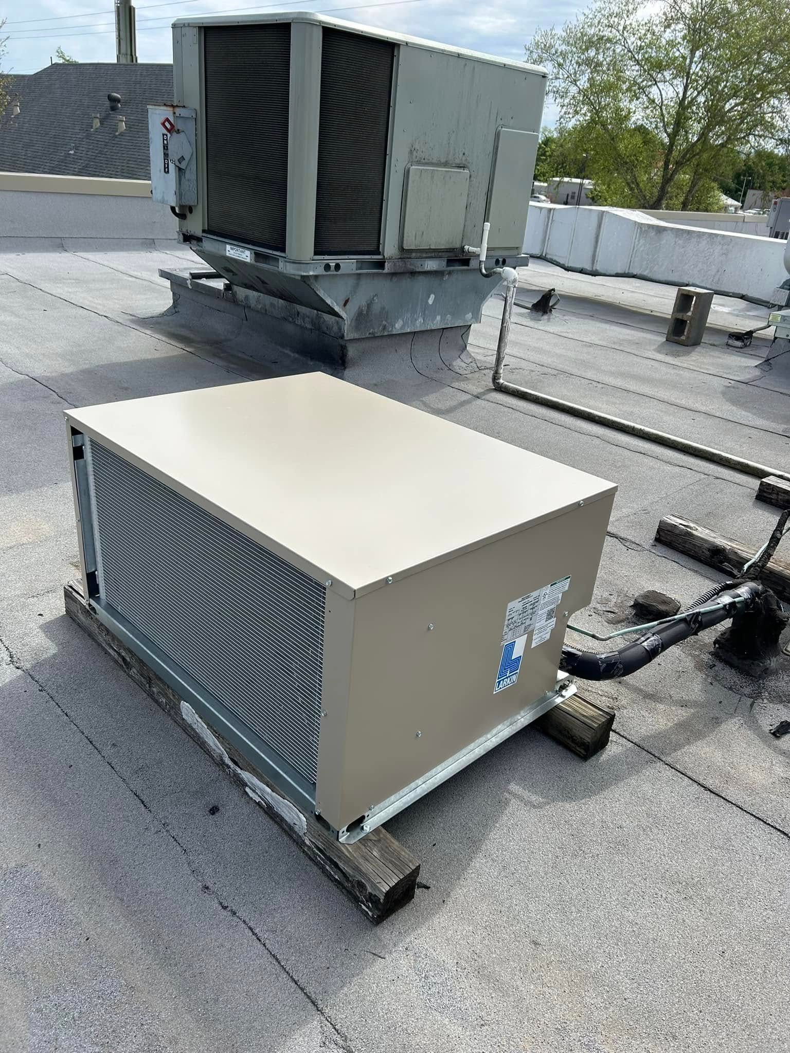 A large air conditioner is sitting on top of a roof.