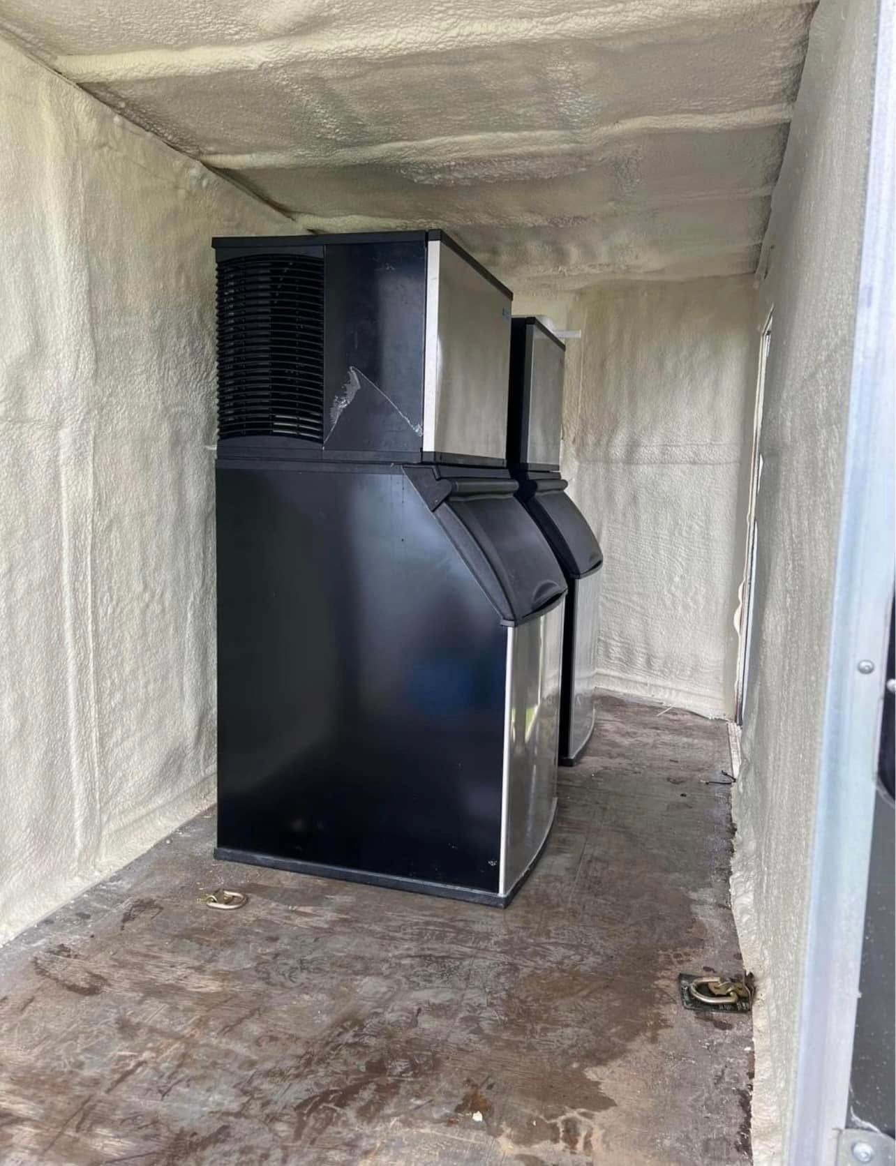 A black ice machine is sitting inside of a room.