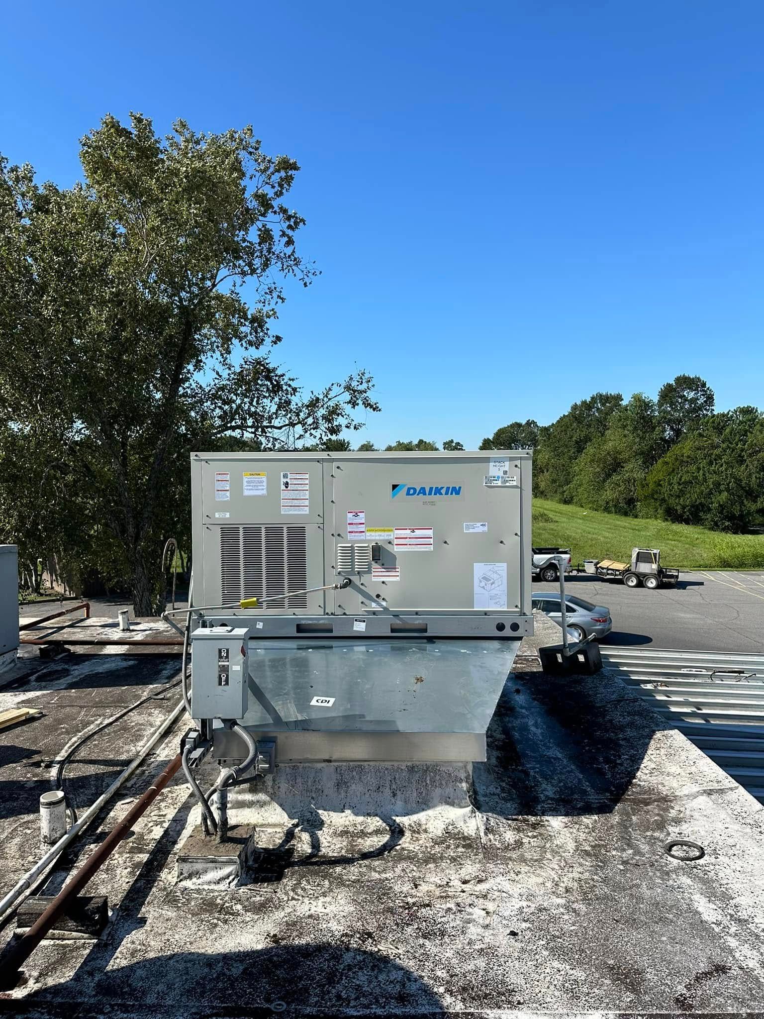A large air conditioner is sitting on top of a roof.