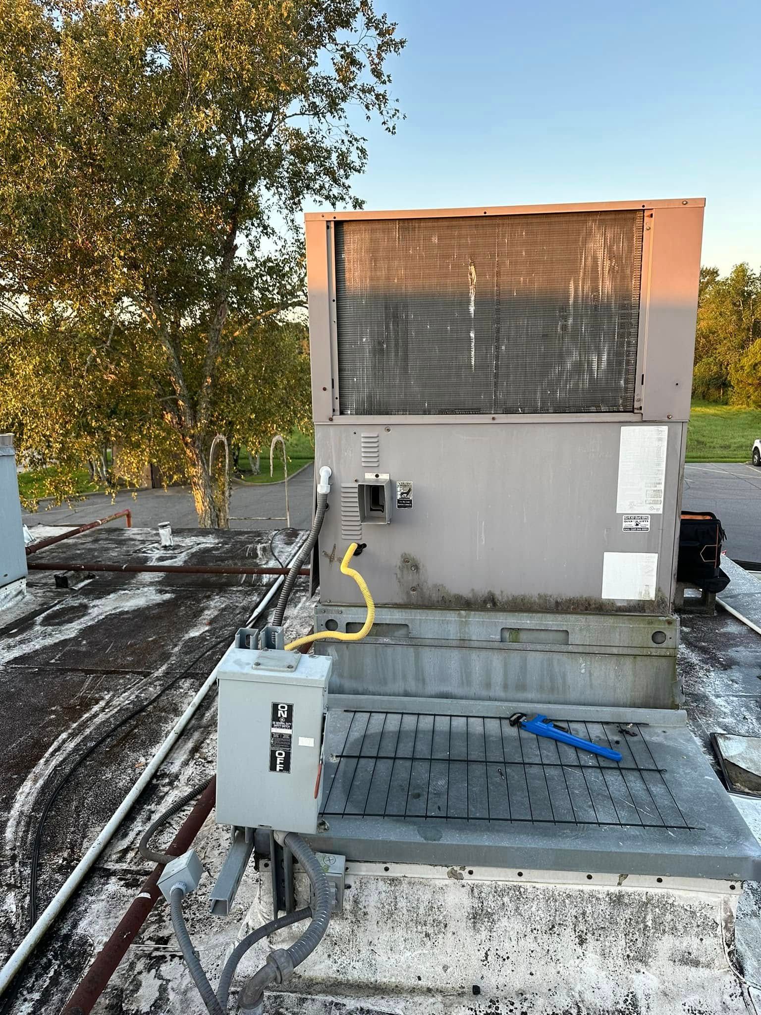 A large air conditioner is sitting on top of a roof.