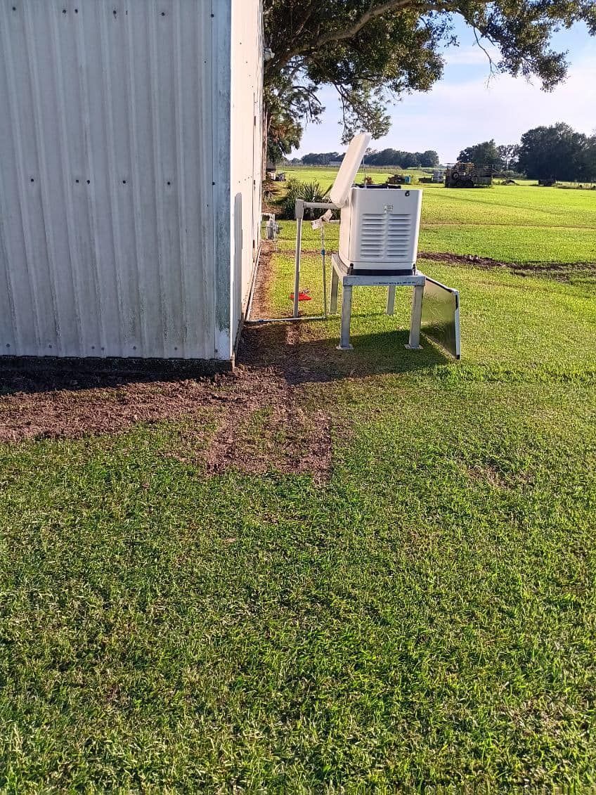A white chair is sitting in the grass next to a shed.