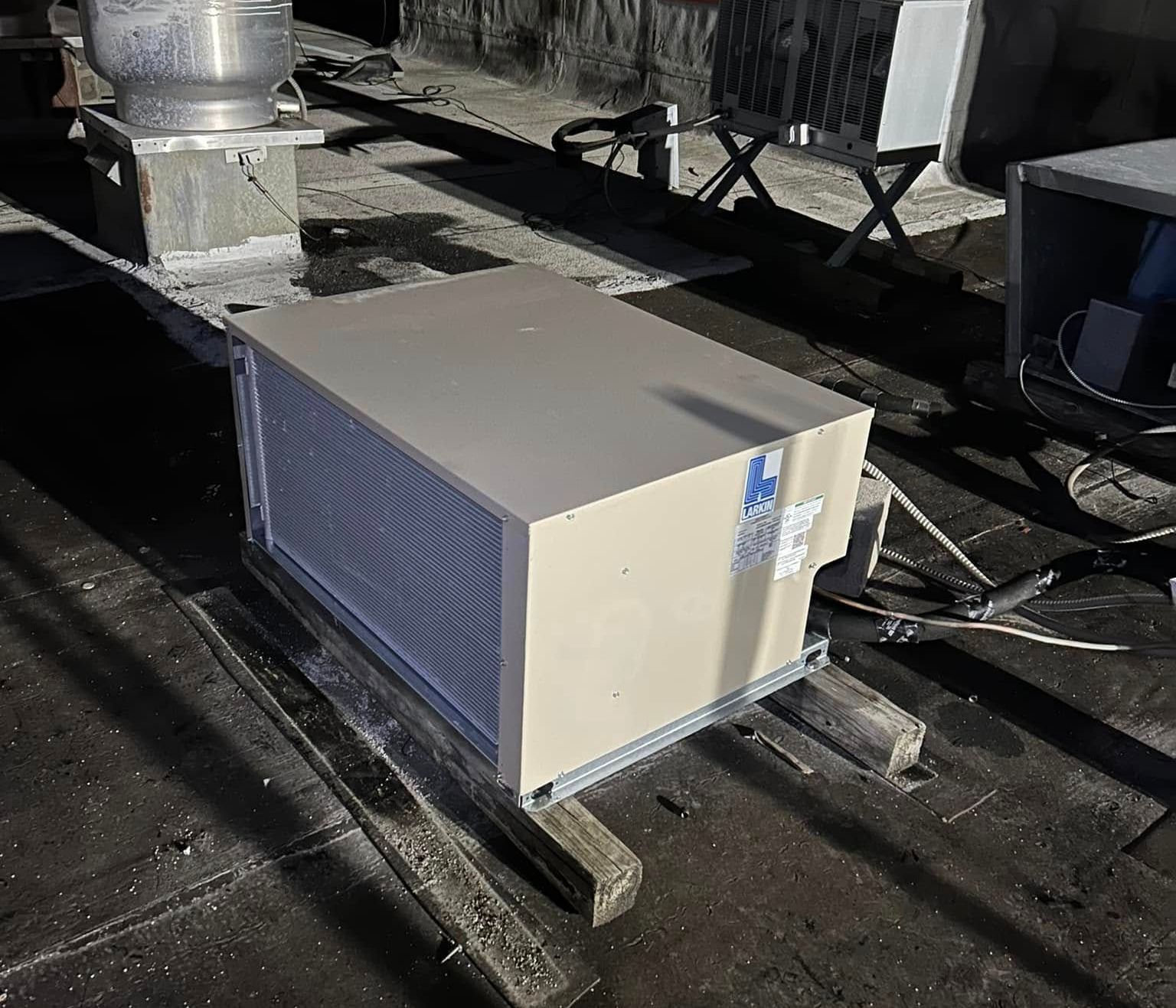 A box is sitting on top of a wooden pallet on a roof.