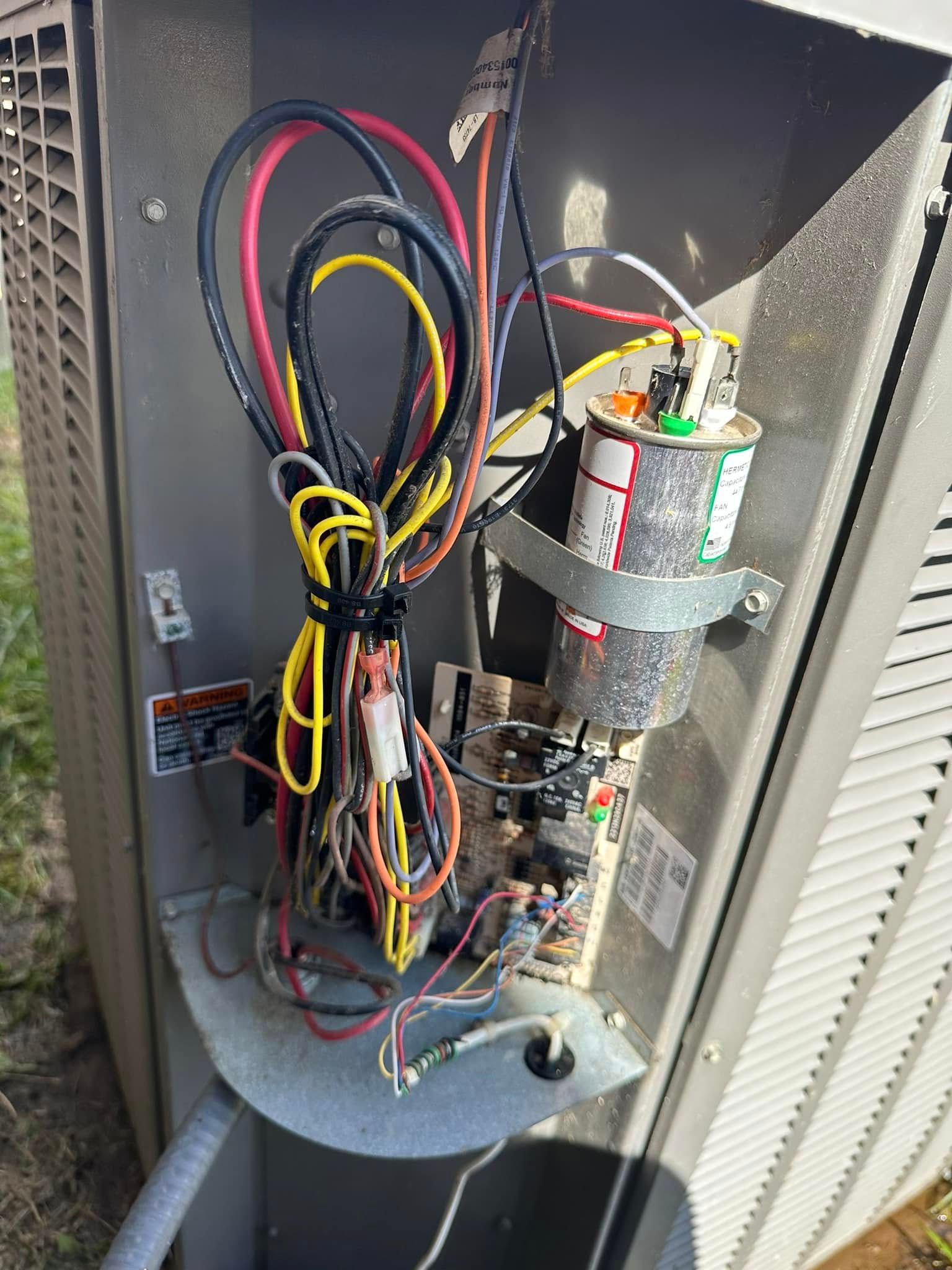 The inside of an air conditioner with a lot of wires coming out of it.