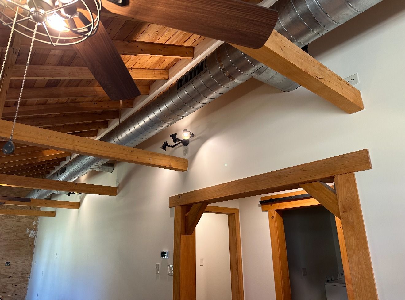 A hallway with wooden beams and a ceiling fan