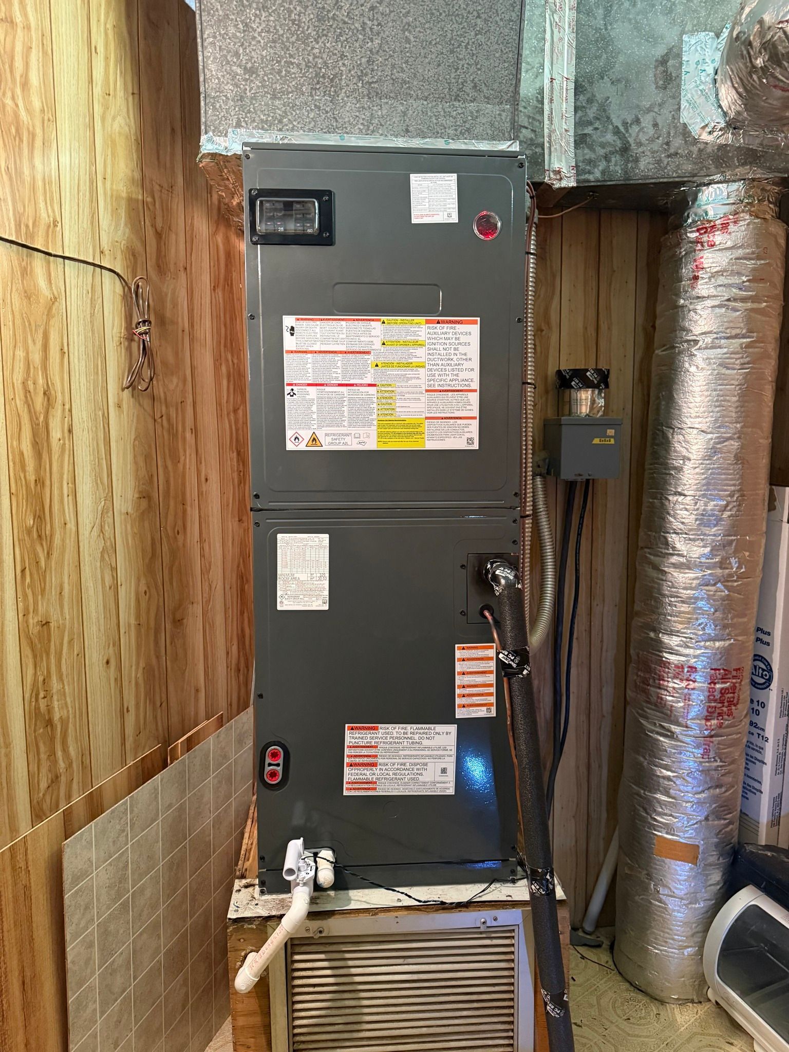 An air conditioner is sitting on top of a heater in a room.