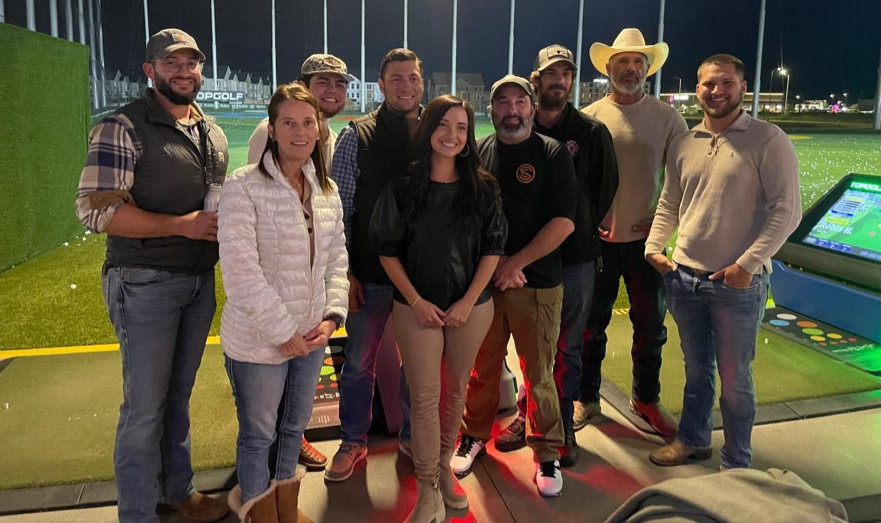 A group of people are posing for a picture on a golf course.