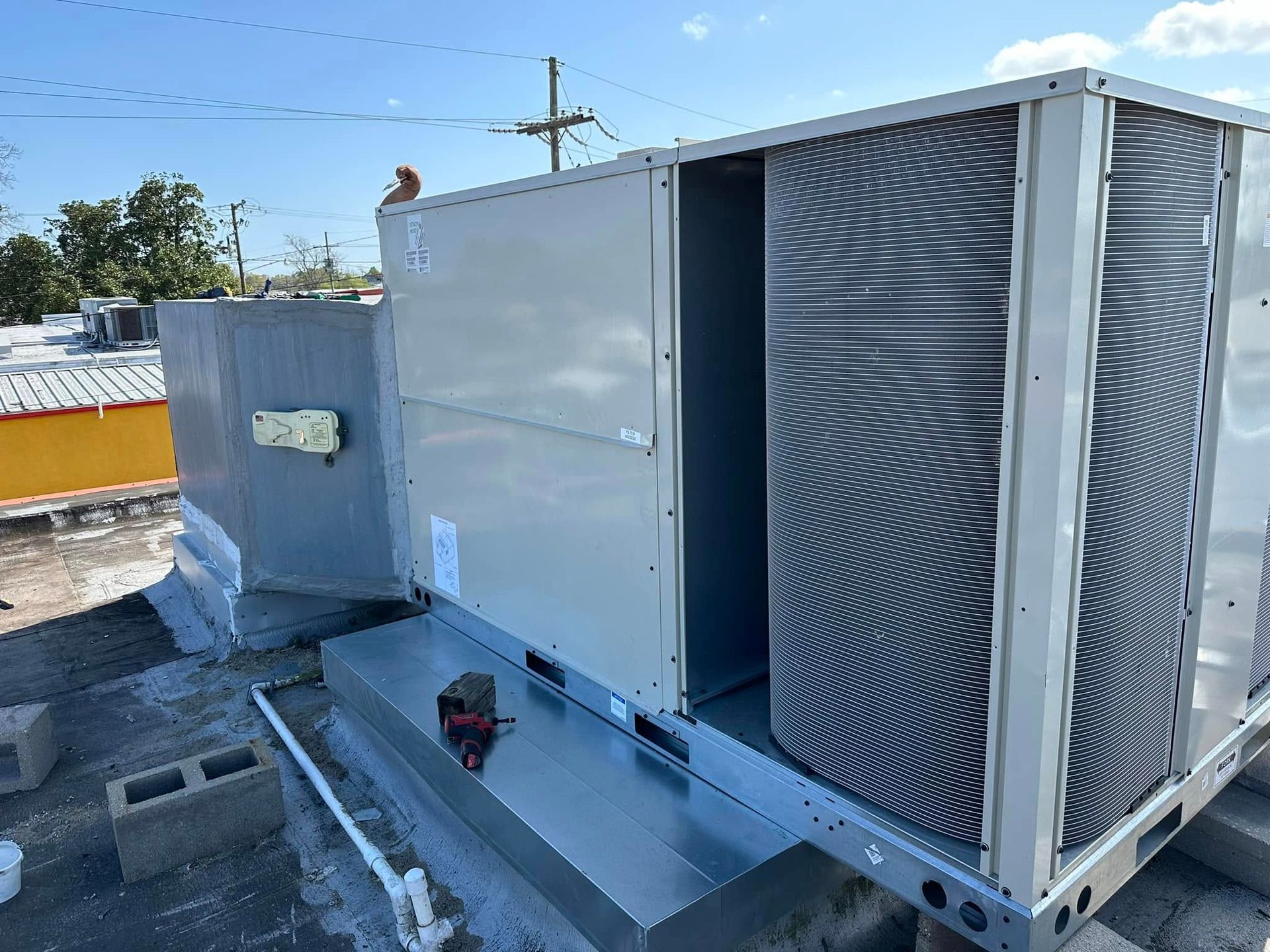 A large air conditioner is sitting on top of a roof.