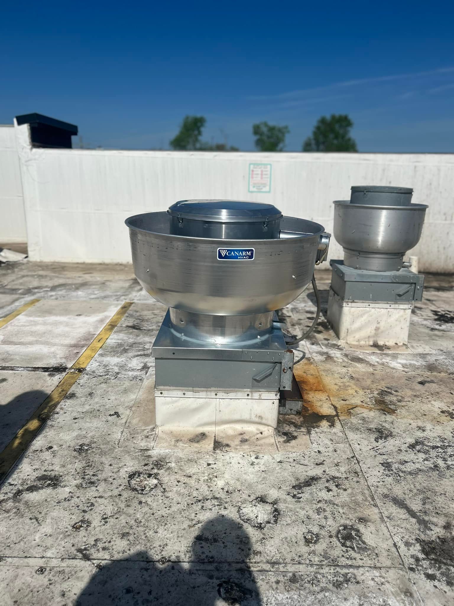 There are two exhaust fans on the roof of a building.