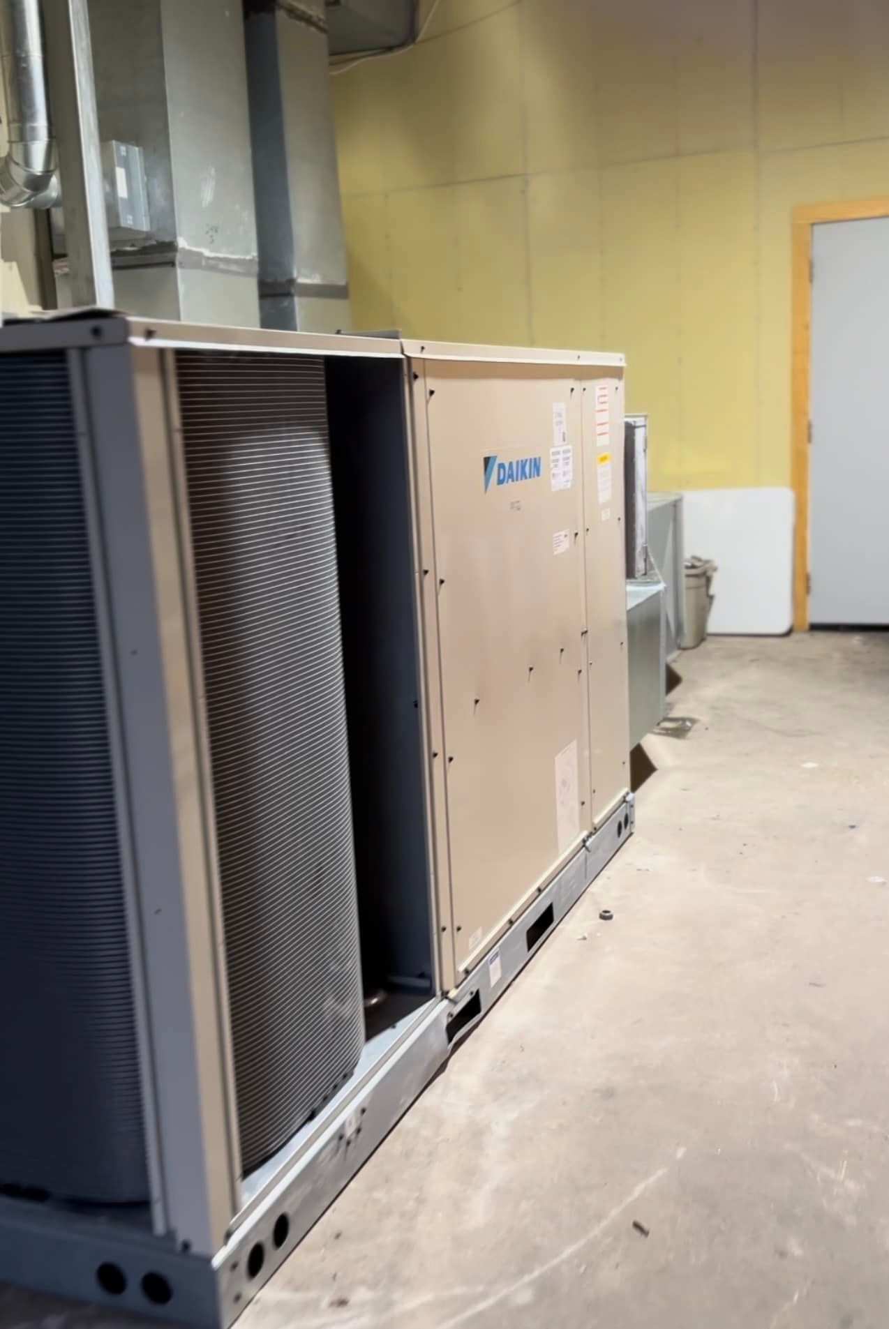 A large air conditioner is sitting on the floor in a room.