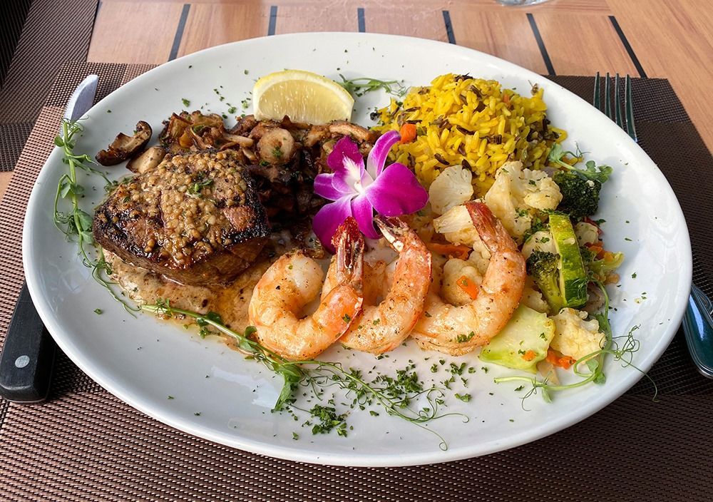 A plate of food with shrimp and rice on a table.