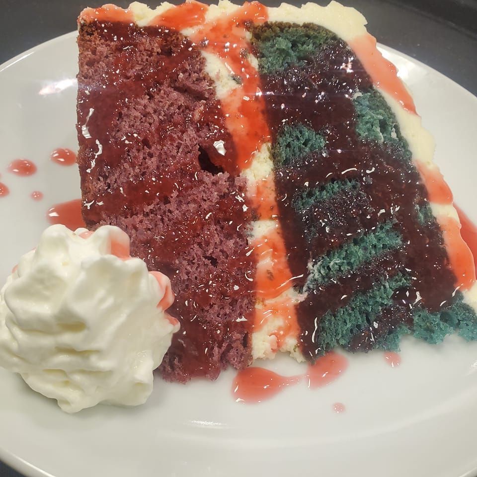 A slice of cake with whipped cream on a white plate