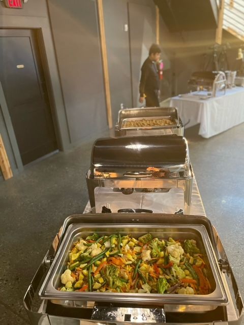 A bunch of trays of food are sitting on a table.