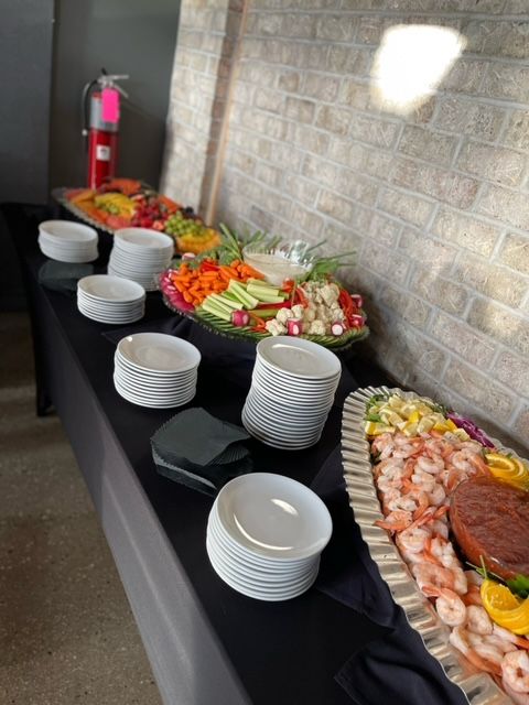 A buffet table with plates and bowls of food on it.