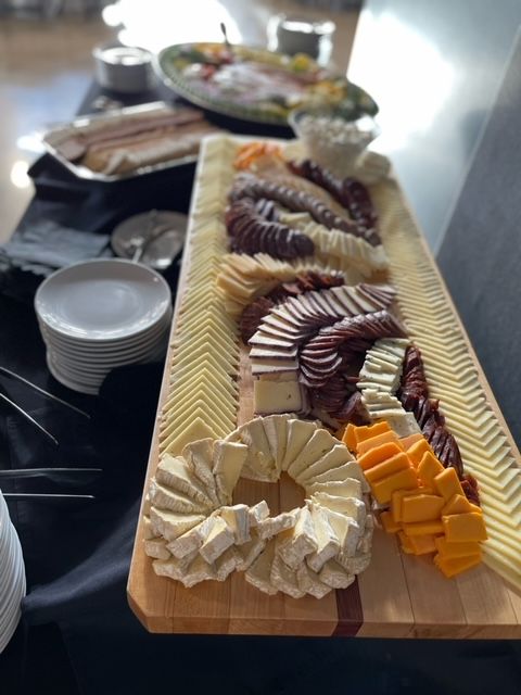 A wooden cutting board with a variety of cheeses on it