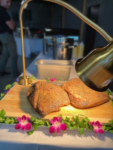 Two pieces of meat are sitting on a wooden cutting board under a light