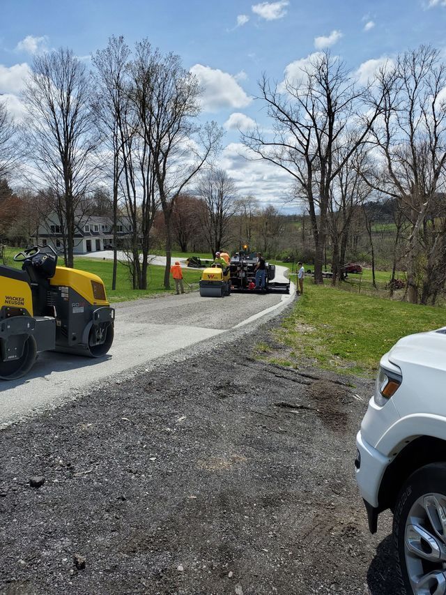 A white truck is parked on the side of a dirt road.