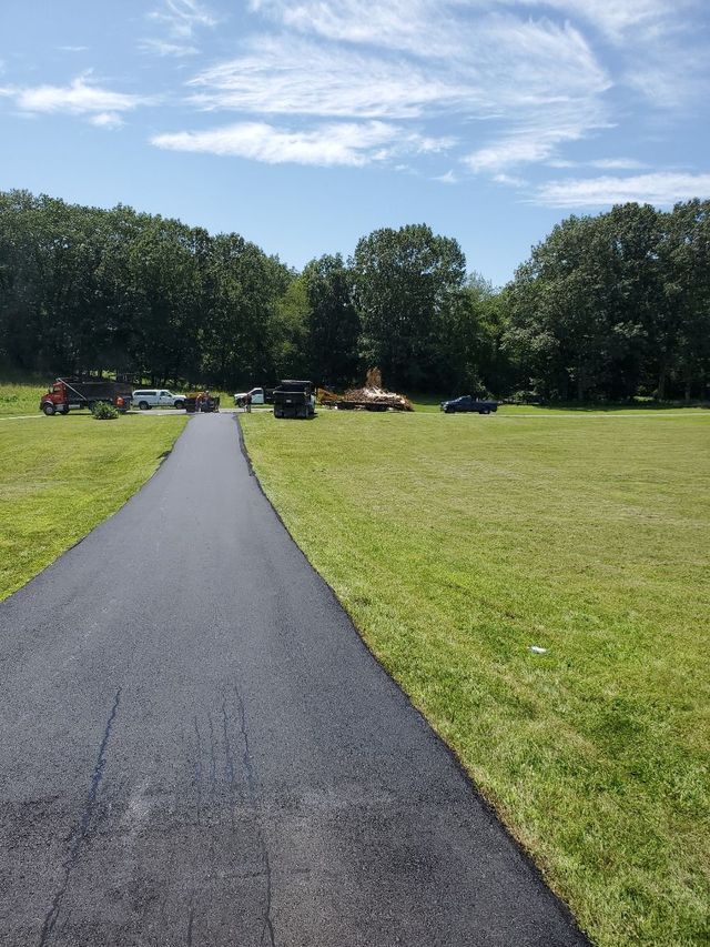 A road that is going through a grassy field.