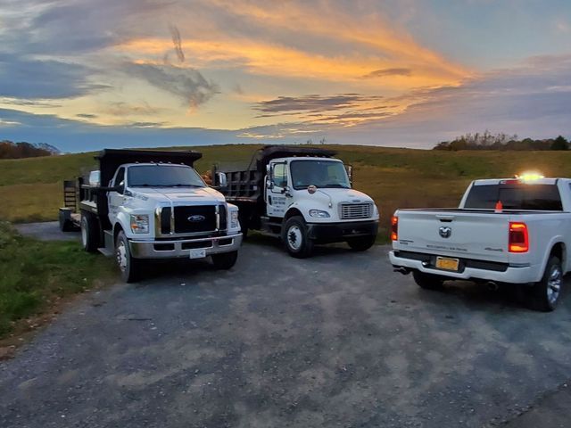 Three trucks are parked on the side of the road.