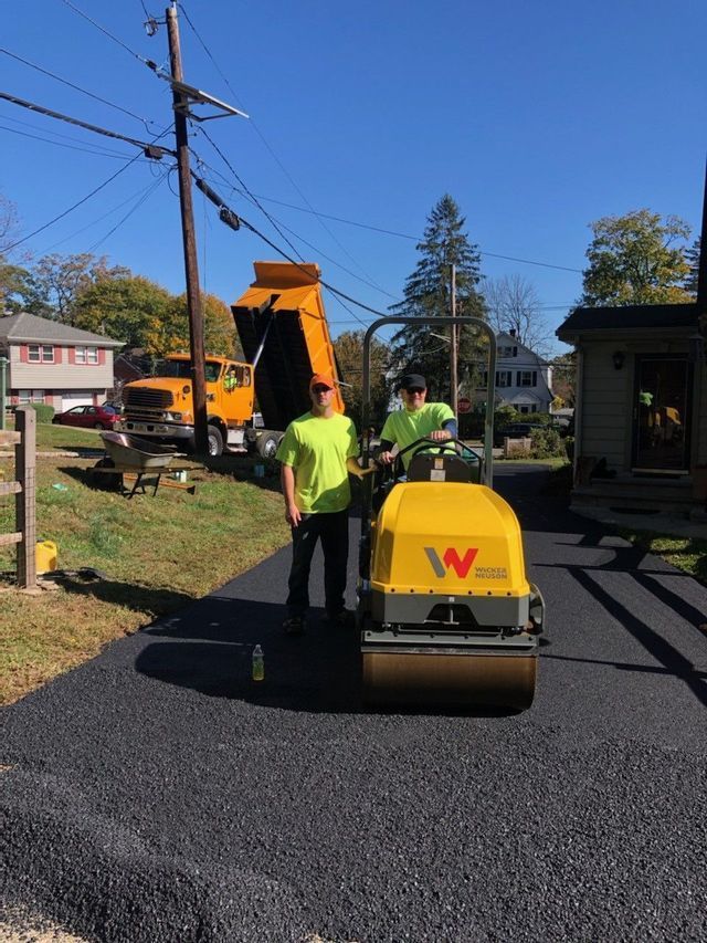 Two men are standing next to a yellow machine that says w on it.