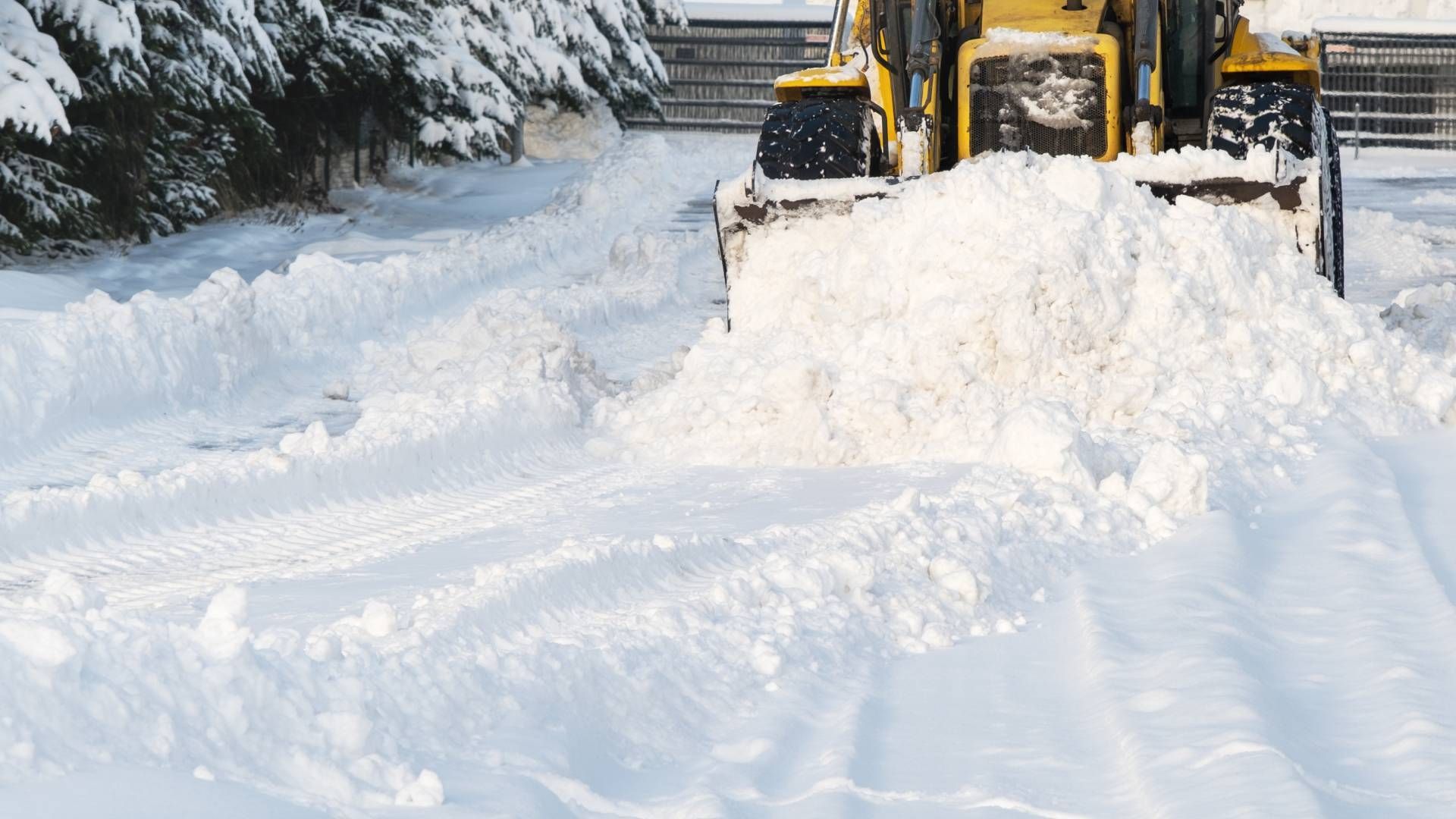 Two men are standing next to a yellow machine that says w on it.
