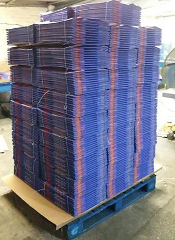 Large stacks of blue cardboard boxes flat packed and tied with cable ties