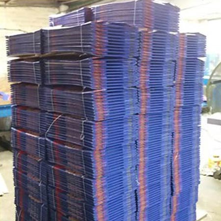Large pallets of flat packed blue cardboard boxes wrapped in cellophane