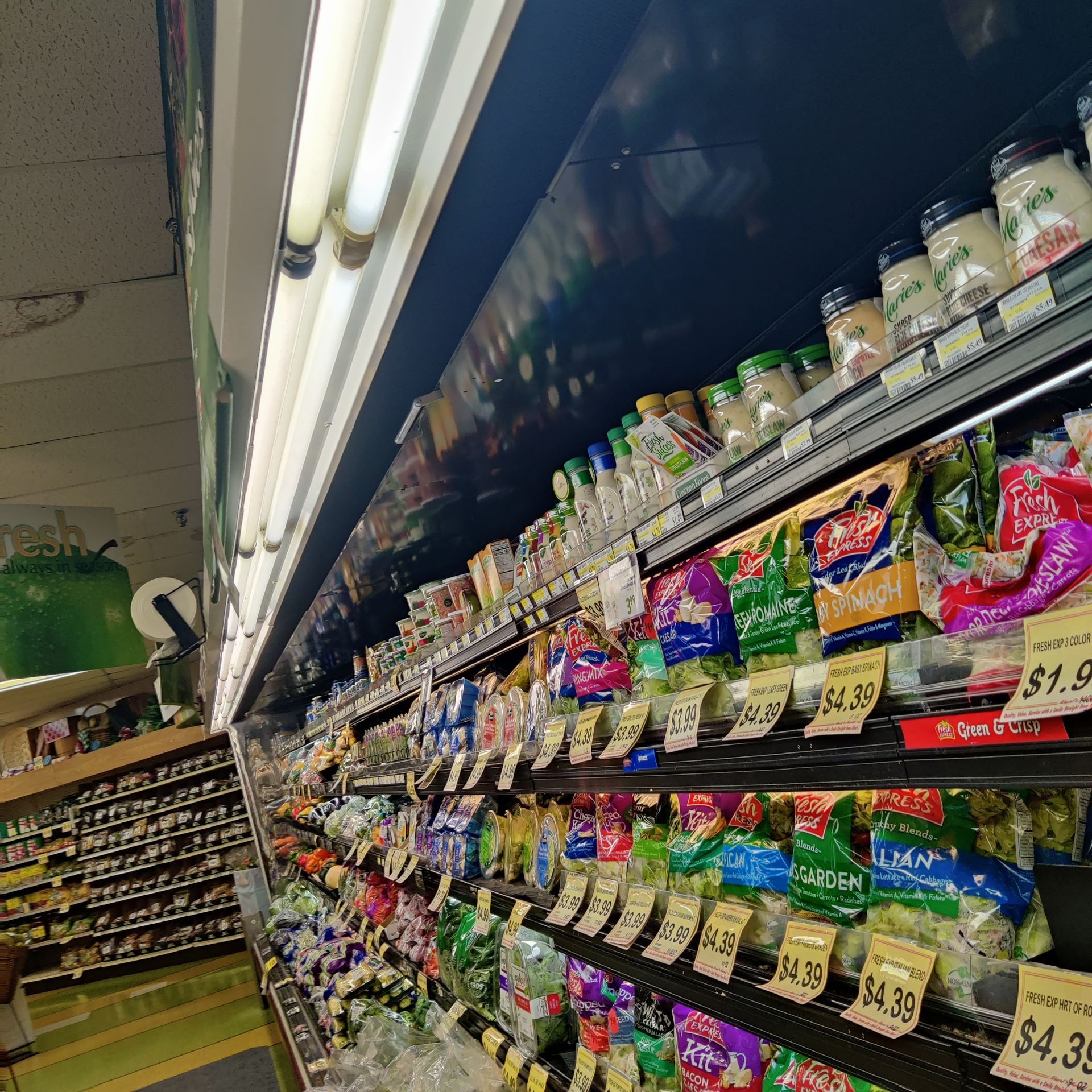 Grocery store aisle with colorful snack bags and price tags on shelves under fluorescent lights
